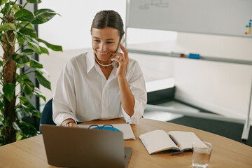 A Professional Woman Engaged in an Important Business Call at a Modern Workspace Environment