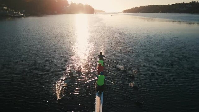 Aerial view Halifax Bay Rowing Crew at Sunrise. A rowing team, captured by a drone, moves gracefully through Halifax Bay at sunrise, their synchronized strokes creating ripples on the water.