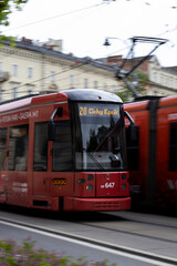 Fototapeta premium two red trams are moving in Poland. Street photo. Motion blur
