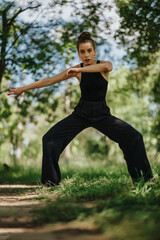 Lovely girl dancing in nature, female dancer performing modern dance moves in a beautiful outdoor environment