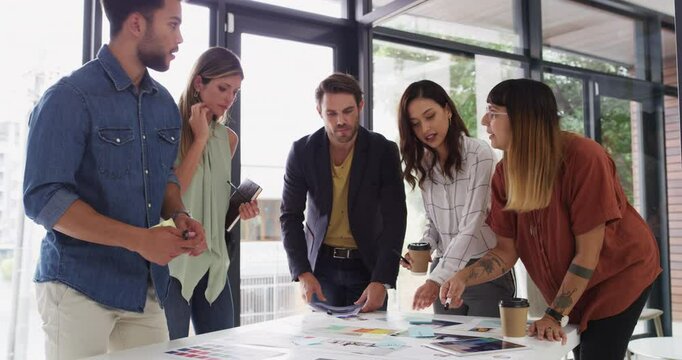 Designer, team and brainstorming for color choice with thinking, talk or tablet for writing notes. Men, women and graphic design for planning, creative or collaboration for solution in startup office