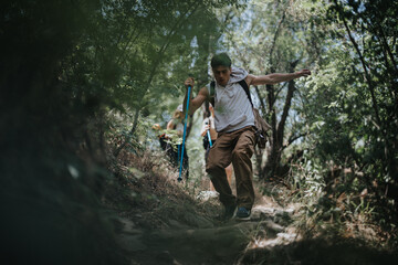 Obraz premium Group of friends hiking through a lush forest trail, enjoying the sunny summer day and the adventure of exploration and healthy outdoor lifestyle.