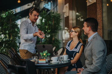 Casual business meeting in an outdoor cafe as colleagues engage in a lively discussion. Perfect for concepts of teamwork, collaboration, and relaxed professional environments.