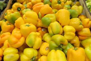 yellow peppers in a market,A pile of peppers for sale at a local vegetable market