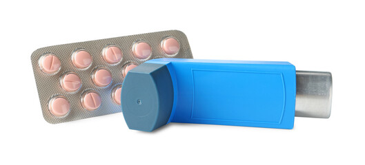 Asthma treatment. Inhaler and pills isolated on white