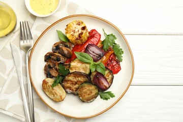 Delicious grilled vegetables with spices served on white wooden table, flat lay