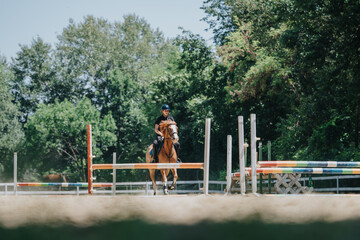 A rider on horseback navigates a jump in an outdoor equestrian arena, showcasing skill and...