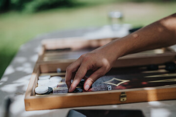 Close-up of hand playing backgammon outdoors on a sunny day