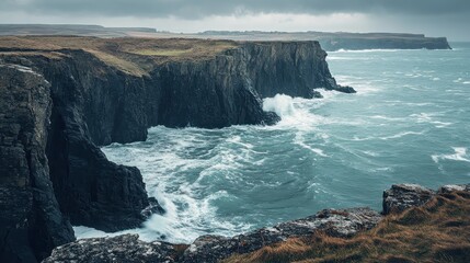 Dramatic Ocean Waves Crashing Against Rugged Cliffs on a Cloudy Day.