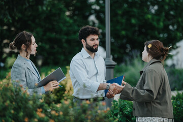 Young entrepreneurs brainstorming ideas and discussing business strategies in an outdoor setting,...