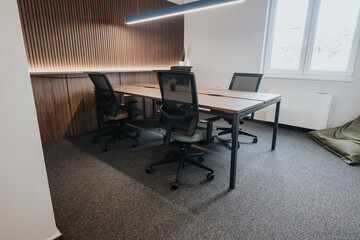 A sleek, modern office featuring ergonomic chairs, wooden desks, and a stylish wooden slat wall. Ideal for business and office settings.