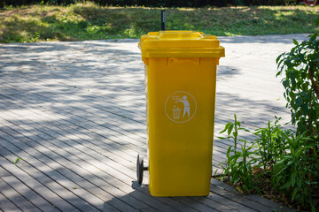 Yellow trash with symbol at the park