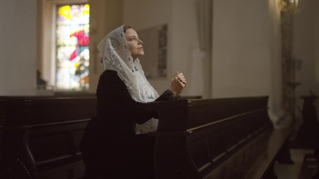 Side view of a woman praying at the church