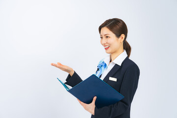 ファイルを持って接客するスーツのミドル女性