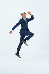 Full-body photo of a Black male business person jumping in front of a white background