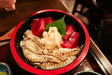 close up of Japanese raw sashimi fish tuna flatfish rice donburi in a red and black bowl