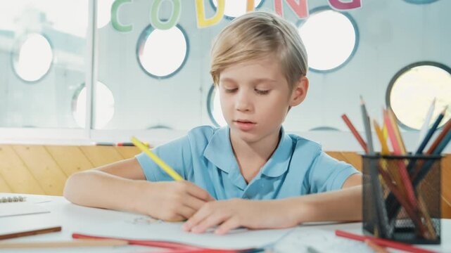 Smiling happy boy coloring creative picture and looking at camera. Smart active caucasian child excited or enjoy to learning coloring color book in online test. Creative learning education. Erudition.