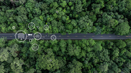 Aerial view car drive in green tree forest road winding road through the forest, Car drive on asphalt road between green tree forest, Electric vehicle EV car drive on asphalt road green tree forest.