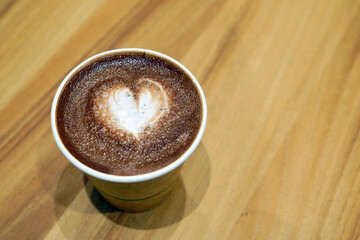 A cup of hot chocolate with painted hearts in a white cup on a wooden background, Coffee time concept, Coffee break time.