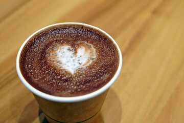 Fototapeta premium A cup of hot chocolate with painted hearts in a white cup on a wooden background, Coffee time concept, Coffee break time.