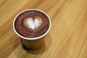 Fototapeta premium A cup of hot chocolate with painted hearts in a white cup on a wooden background, Coffee time concept, Coffee break time.