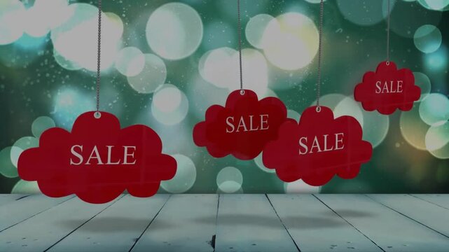Red sale tags hanging over bokeh lights animation on wooden background