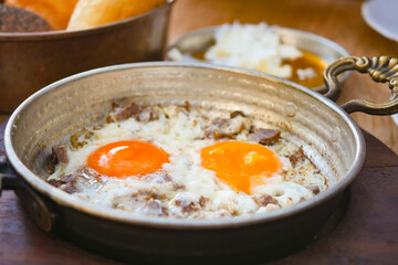 Indulge in Delicious Sizzling Eggs with Meat, all prepared in a Traditional Cooking Pan