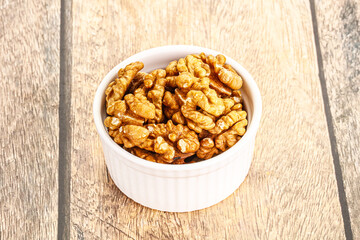 Cracked unshelled walnut in the bowl