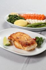 Grilled Cod with vegetables on a plate