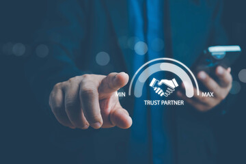Trusted partner. Trustworthy collaboration, company or contract. Confidence to work together. Businessman turning knob to highest trust levels. Build trust in business and finance relationships.