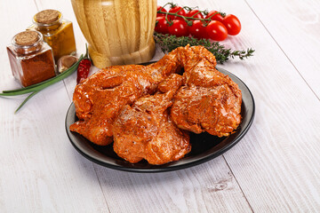 Raw turkey shoulder wing in Indian tandoori marinade