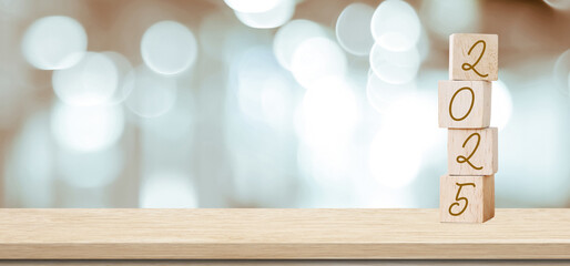 Happy New Year 2025 on wood cube block and blur white abstract bokeh light background with copy space for text, Happy new year 2025 greeting card, banner