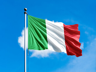 Italy flag flying on blur blue clouds background.