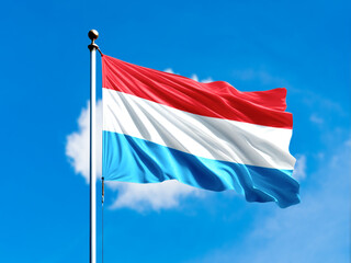luxembourg flag flying on blur blue clouds background.