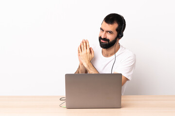 Telemarketer caucasian man working with a headset and with laptop scheming something.