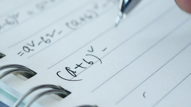 Hand writing algebra equations on a paper 