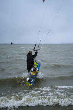Woman packs up his kite surfing equipment as a storm approaches.