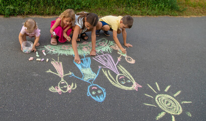 Naklejka premium children draw a family with chalk. Selective focus