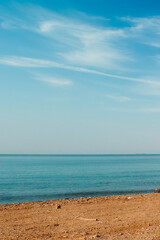 Al Ain Al Sokhna beach, Suez, Egypt, with a clear blue sky and calm sea, meeting the sandy shore