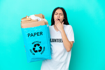 Teenager girl with braids holding a bag to recycle yawning and covering wide open mouth with hand