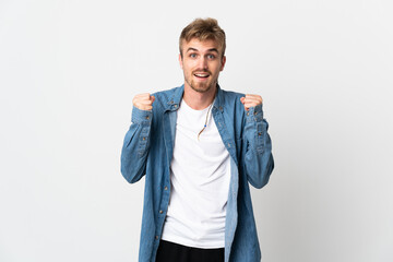 Young handsome man isolated on white background celebrating a victory in winner position