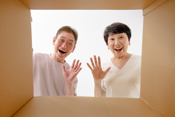 ダンボールを開封するシニア夫婦