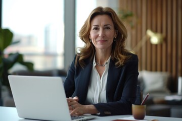 Professional investment advisor at desk with laptop  smiling at camera.