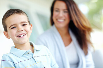 Portrait, relax and smile of boy with mother on sofa in living room of home together for bonding. Face, family or love with happy son and single parent woman in apartment for weekend wellness