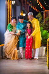 Naklejka premium Indian young family with kids celebrating Diwali festival with sparklers in gallery
