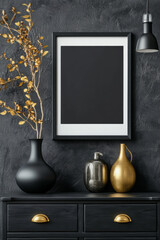 A black framed picture with a black vase and a gold vase on a table