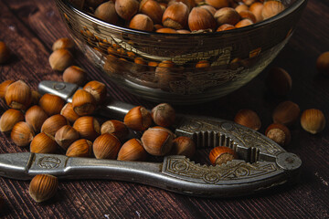 Hazelnuts and nutcracker on wooden background