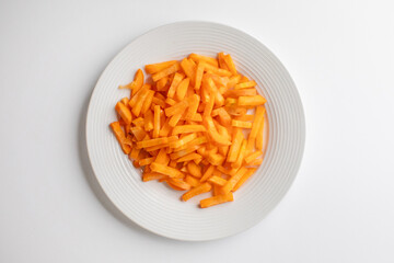 A white plate filled with raw, julienned carrots ideal for healthy meal preparation and vegan diet illustrations