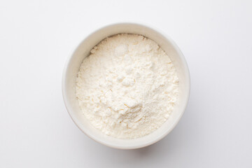 Top view of a white ceramic bowl filled with flour, perfect for illustrating baking ingredients or cooking blogs