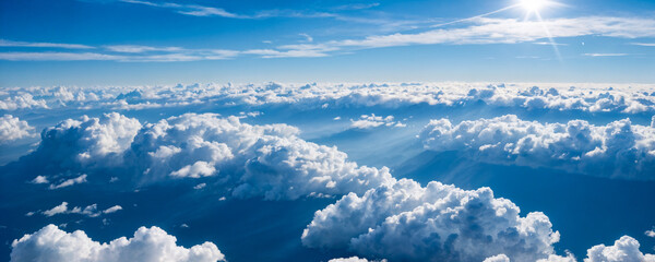 Fluffy white clouds blanket the sky with sun rays filtering through.